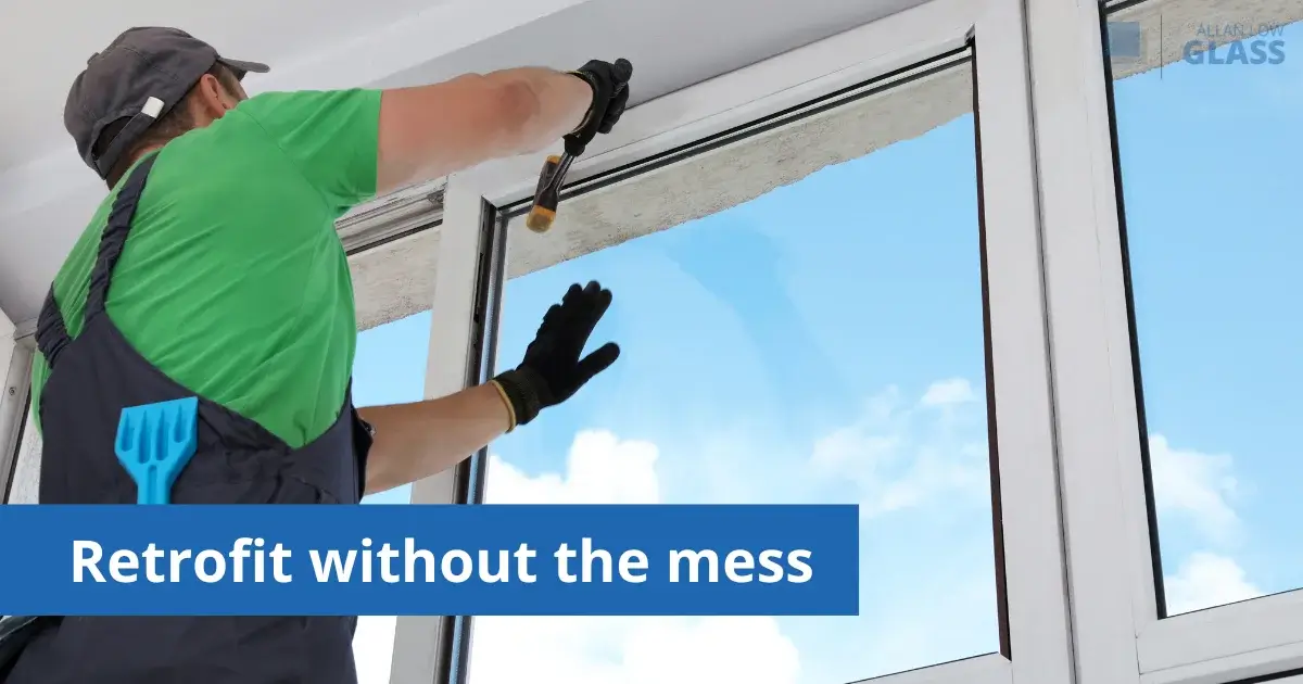 Man installing retrofit glass into residential window frame.