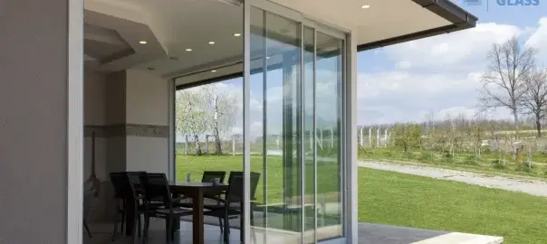 Modern sliding glass doors open to outdoor patio and garden.
